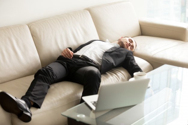 9799c-tired-businessman-sleeping-sofa-office_1163-5491